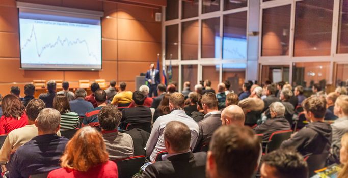 Speaker giving a talk in conference hall at business event. Audience at the conference hall. Business and Entrepreneurship concept.