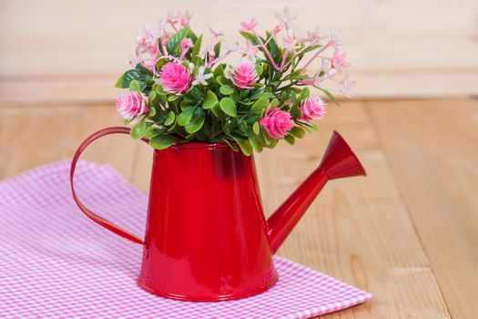 flowers in red watering on wood