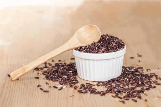Rice berry in bowl on wood background
