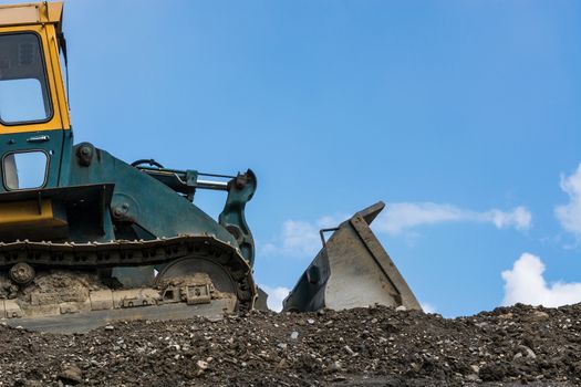 Construction machinery at a construction site in the background a blue sky.