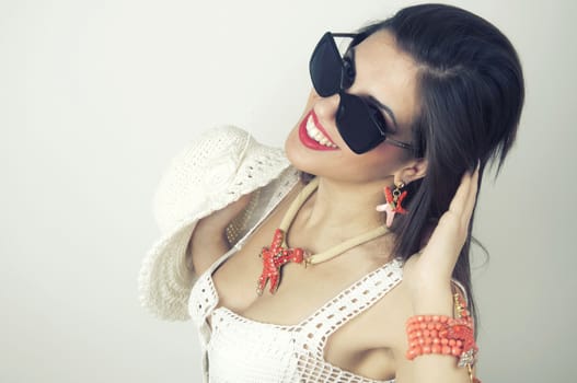 Woman smiling with perfect smile wearing sunslusses and jewlry