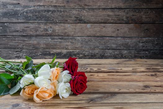 Beautiful roses on wooden table, rustic style