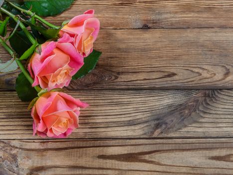 Beautiful roses on wooden table, rustic style