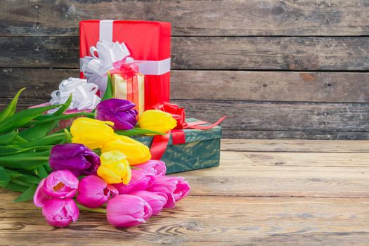 Beautiful tulip flowers on rustic wooden background 