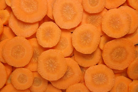 Circles of sliced raw carrot as an abstract background texture