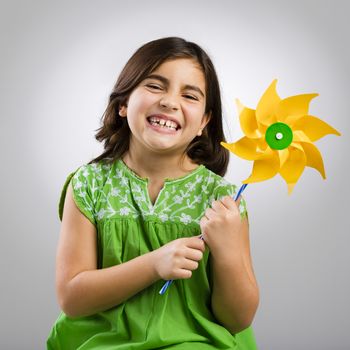 Studio portrait of a little girl playing with a windmill