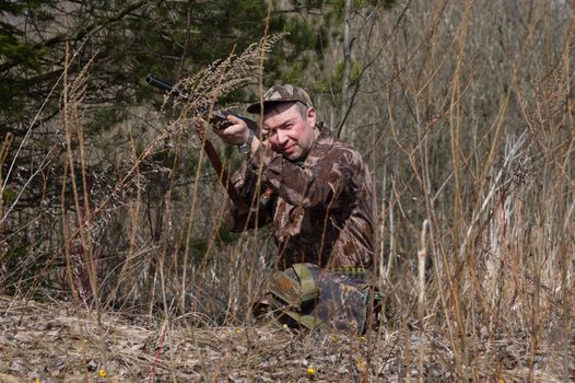 Outdoor shot of man aiming a shotgun.