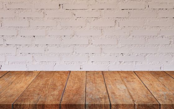 Brown wooden table top with white brick wall decorated in coffee shop