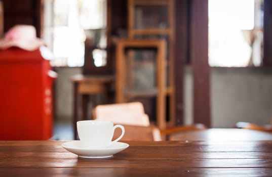 White coffee cup on wooden table in coffee shop