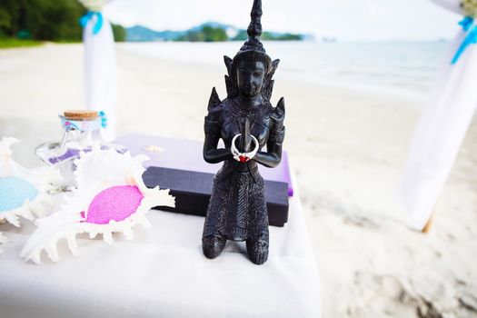 Statue with wedding rings on the beach of Thailand