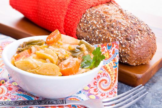 Bowl of delicious hot healthy Turkish leek soup served with a loaf of wholegrain bread with flax seeds for a tasty starter to a winter meal