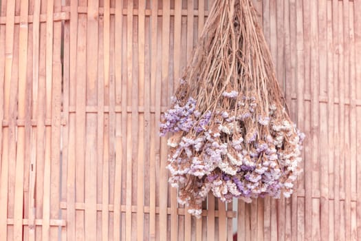 Bouquet of dried flowers hanging on bamboo background, stock photo