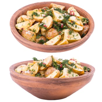 Baked potatoes with spices in an old clay bowl. Selective focus.