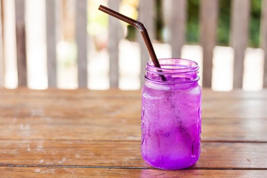 Iced drink in violet glass in coffee shop, stock photo