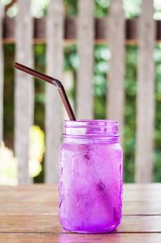 Iced drink in violet glass in coffee shop, stock photo