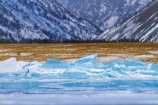 Bloks of ice on Baikal lake and mountains