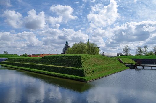 Renaissance castle and fortress of Kronborg, home of Shakespeare's Hamlet. View to moat and walls of the fortress, with reflection on water, Denmark