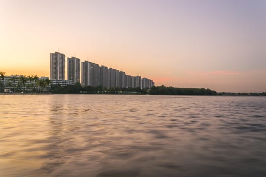 Riverside buildings with blue sky and rainbow