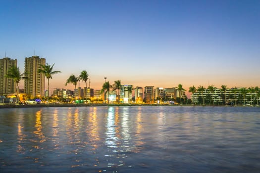 Riverside buildings with blue sky and rainbow