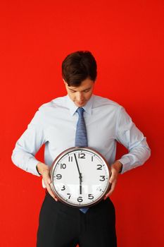 Man with wall clock on red background, deadline concept