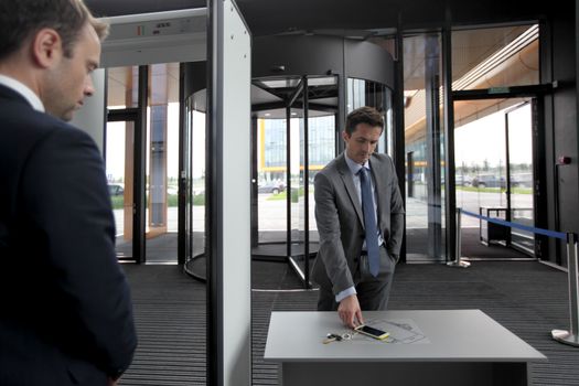 Man at airport security gates putting out phone and keys