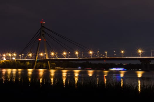 Night bridge above river with reflecting lights