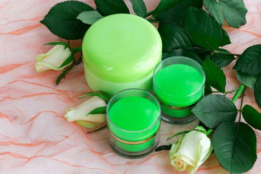 Set of three green cosmetic cream bottles with white roses