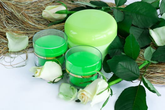 Set of three green cosmetic cream bottles with white roses
