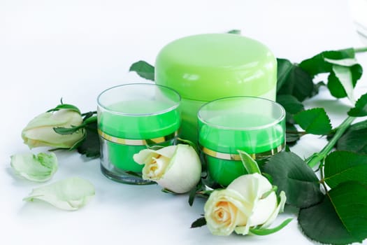 Set of three green cosmetic cream bottles with white roses