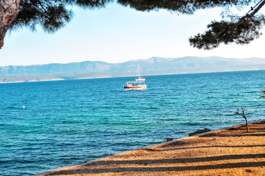Lonely sail boat in Mediterranean sea bay, view from land