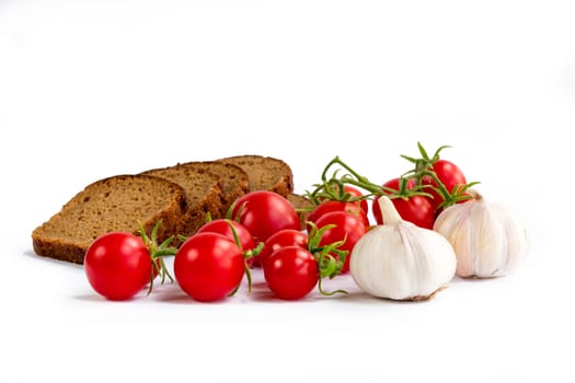 Set of black bread slices, bunch of cherry tomatoes, garlic