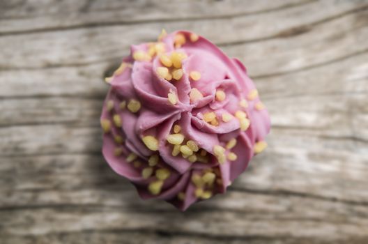 Bright Pink Frosted Cupcake On A Wooden Background