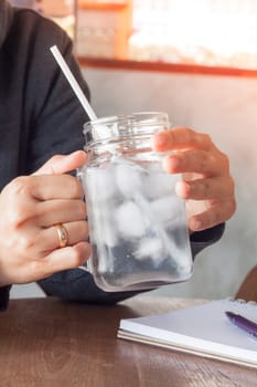 Woman's hand holding a cold glass of water, stock photo