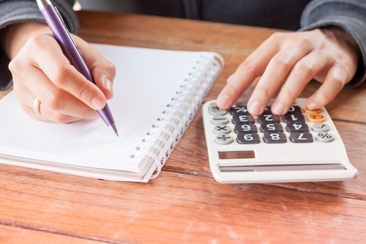 Woman hand with pen writing on notebook, stock photo