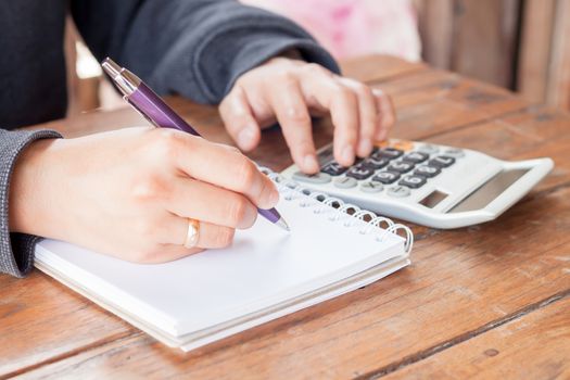 Woman hand with pen writing on notebook, stock photo