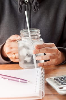 Woman's hand holding a cold glass of water, stock photo