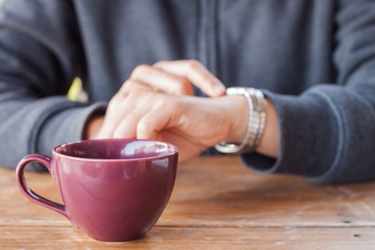 Woman checks the time on a wrist watch, stock photo