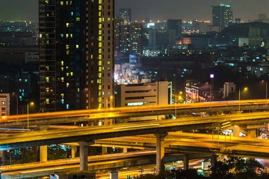 a view over the big asian city of Bangkok , Thailand at nighttime when the tall skyscrapers are illuminated.