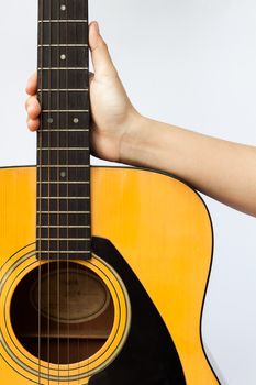 Woman's hand holding acoustic guitar on white background, stock photo