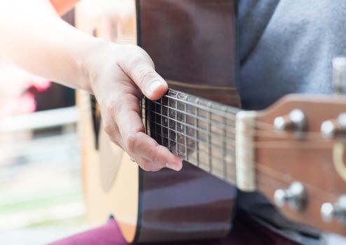 Woman's hands playing acoustic guitar, stock photo