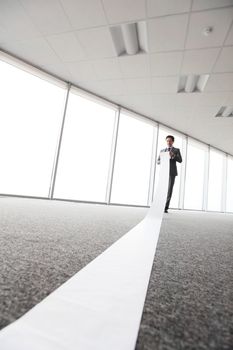 Office worker unrolling long sheet of paper