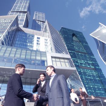 Business people shaking hands, finishing up a meeting outside office