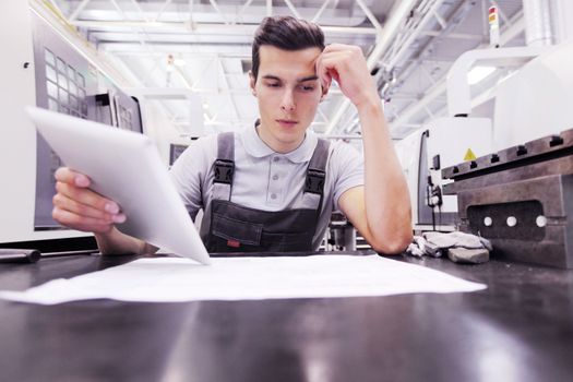 Man working with documents at plant near CNC machines