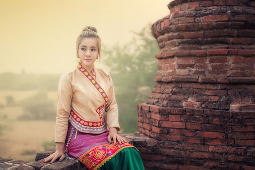 Beautiful girl in Myanmar traditional costume,  identity culture of Myanmar, Pagdodas of Bagan Background, Happy asian woman