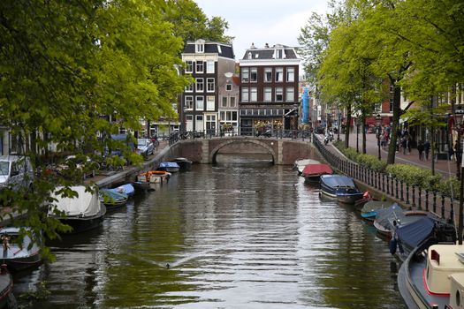 AMSTERDAM, THE NETHERLANDS - AUGUST 18, 2015: View on Prinsengracht from Lijnbaansgracht. Street life, Canal, bicycle and boat in Amsterdam. Amsterdam is capital of the Netherlands on August 18, 2015.