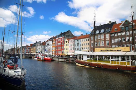 COPENHAGEN, DENMARK - AUGUST 15, 2016: Boats in the docks Nyhavn, people, restaurants and colorful architecture. Nyhavn a 17th century harbour in Copenhagen, Denmark on August 15, 2016.