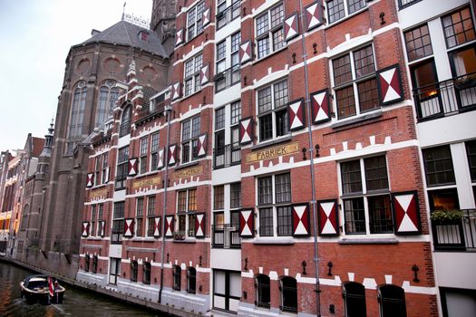AMSTERDAM; THE NETHERLANDS - AUGUST 18; 2015: View on Oudezijds Kolk canal in Amsterdam, building Verf en Vernis Fabriek H.Vettewinke in Amsterdam. Amsterdam is capital of the Netherlands on August 18; 2015.