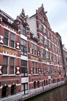 AMSTERDAM; THE NETHERLANDS - AUGUST 18; 2015: View on Oudezijds Kolk canal in Amsterdam, building Verf en Vernis Fabriek H.Vettewinke in Amsterdam. Amsterdam is capital of the Netherlands on August 18; 2015.