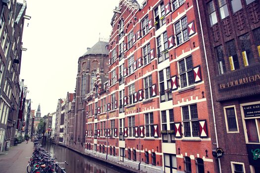 AMSTERDAM; THE NETHERLANDS - AUGUST 16; 2015: View on Oudezijds Kolk canal in Amsterdam, building Verf en Vernis Fabriek H.Vettewinke in Amsterdam. Amsterdam is capital of the Netherlands on August 16; 2015.