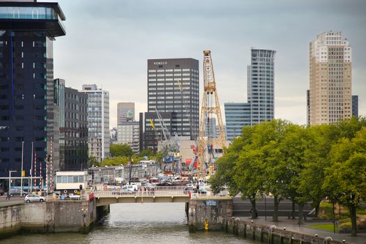 ROTTERDAM, THE NETHERLANDS - 18 AUGUST: Old cranes in Historical Leuvehaven, Rotterdam's oldest sea port. Harbor and modern apartment buildings in Rotterdam, Netherlands on August 18,2015.